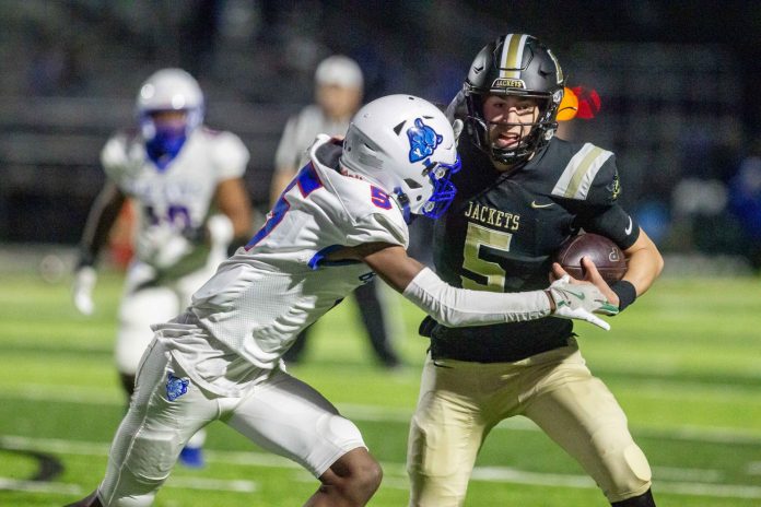 Perrysburg senior quarterback Josh Takats (5) fights off a Springfield tackler. (Kenneth Falls Photography)